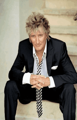 Man in Suit on Stairs With Hands Folded