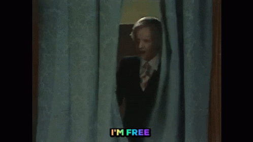 Man In Suit Peeking Out Behind Curtain GIF