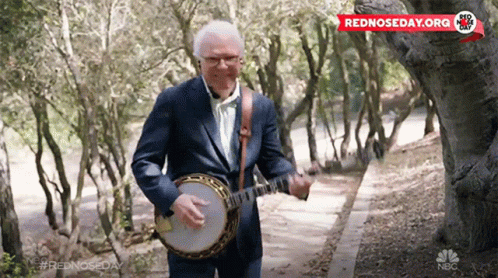 Man in Suit Playing Banjo in Woods Sponsored by NBC