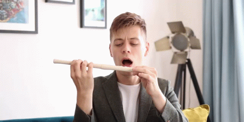 Man in Suit Playing Flute with Open Mouth