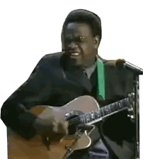 Man in Suit Playing Guitar at Microphone