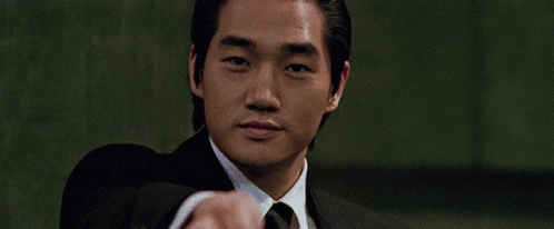Man in Suit Pointing at Camera Green Background