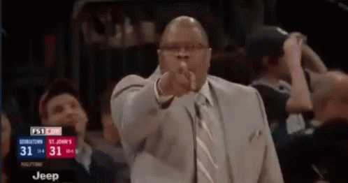Man in Suit Pointing at Camera
