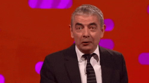 Man in Suit Pointing Up Saying It's Mr. Bean