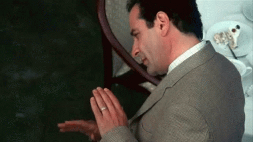 Man in Suit Praying with Folded Hands