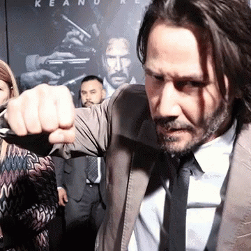 Man in Suit Raising Fist Keanu Reeves Poster