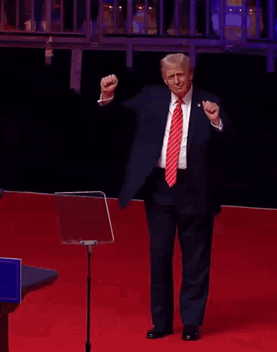 Man in Suit Raising Fist on Red Carpet