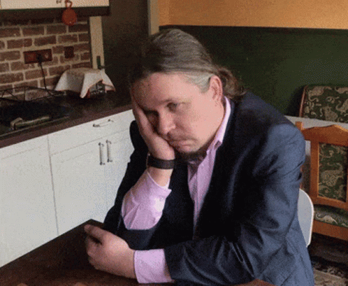 Man In Suit Resting Head On Hands GIF