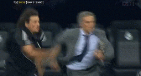 Man in Suit Running From Man in Black Shirt