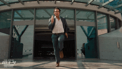 Man in Suit Running Past Mission Impossible Building