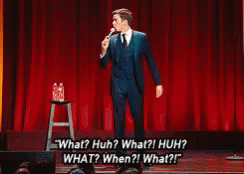 Man in Suit Saying What Huh on Stage