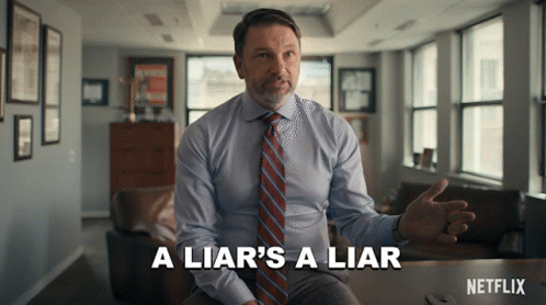 Man in Suit Says A Liar's a Liar Sitting at Table