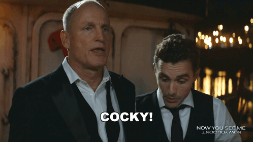 Man in Suit Says Cocky in Front of Another Man