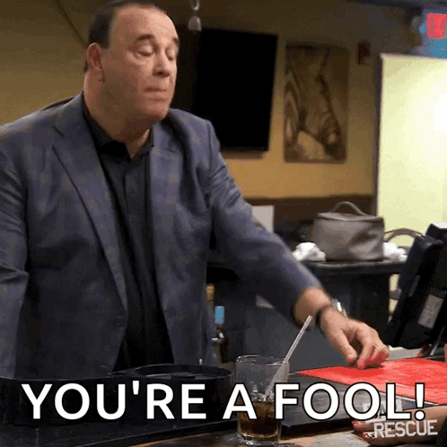 Man in Suit Says You're a Fool Holding Glass