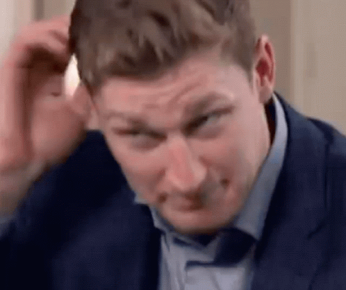 Man in Suit Scratching Head