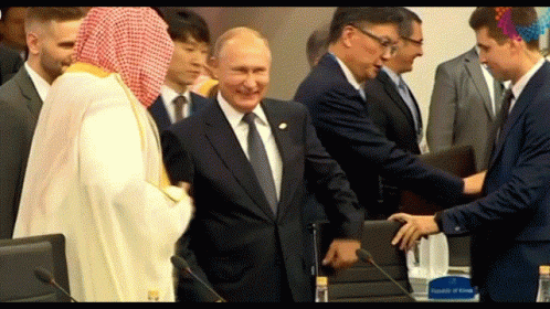 Man in Suit Shaking Hands with Man in White Robe
