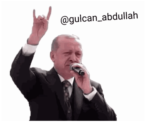 Man in Suit Singing and Giving Devil Horns