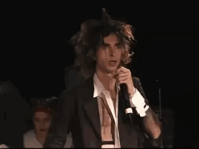 Man In Suit Singing Into Microphone On Stage GIF