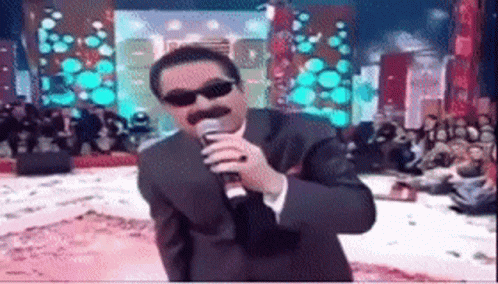 Man in Suit Singing Into Microphone With Sunglasses