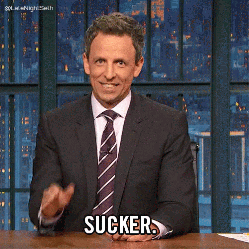 Man In Suit Sitting At Desk Saying Sucker GIF
