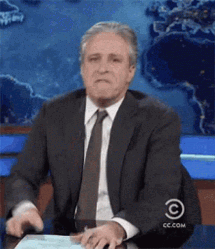 Man In Suit Sitting At Desk With CC.com Logo GIF