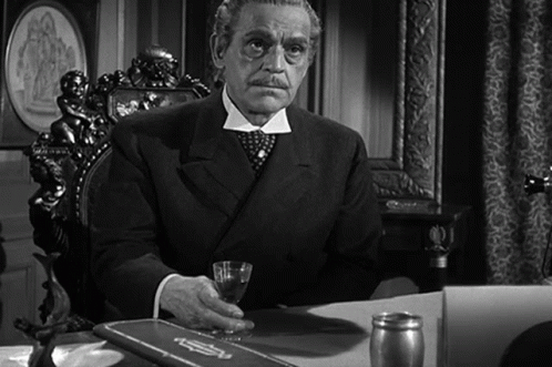 Man in Suit Sitting at Desk with Glass