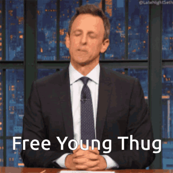 Man in Suit Sitting at Table Says Free Young Thug