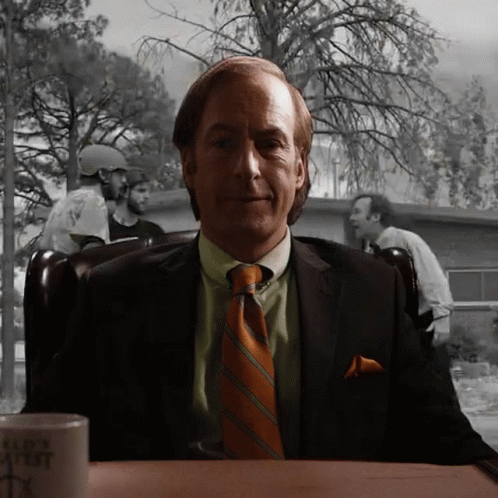 Man in Suit Sitting at Table With Bad Ass Mug