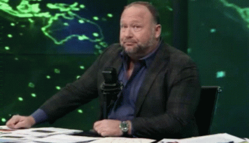 Man in Suit Sitting at Table with Microphone