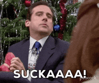 Man In Suit Sitting By Christmas Tree Saying Suckaaa GIF