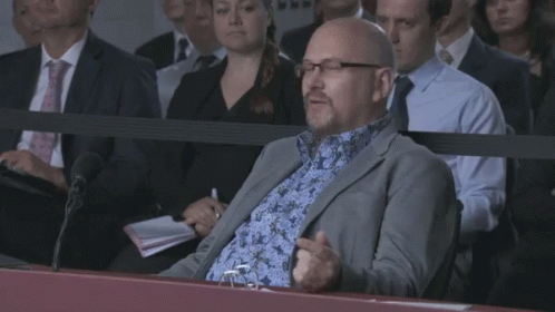 Man in Suit Sitting in Crowd Saying I'm Just a Lad