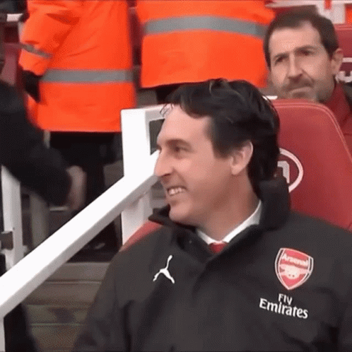 Man in Suit Sitting in Empty Stadium With Arsenal Media