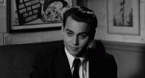 Man in Suit Sitting in Front of Eye of Camera Poster