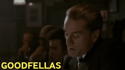 Man in Suit Sitting in Front of Goodfellas Screen