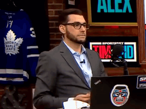 Man in Suit Sitting in Front of Laptop With Toronto Maple Leafs Jersey