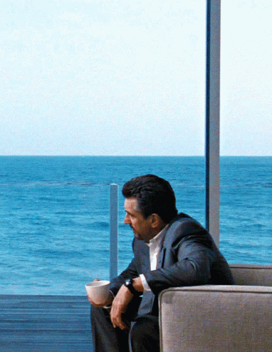 Man in Suit Sitting with Coffee