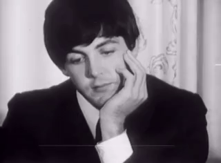 Man in Suit Sitting With Hand on Chin