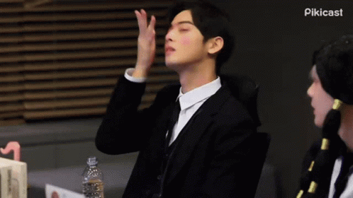 Man in Suit Sitting With Hand on Face Eyes Closed