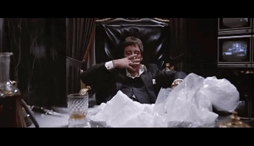 Man in Suit Sitting with Whiskey and Cigarette
