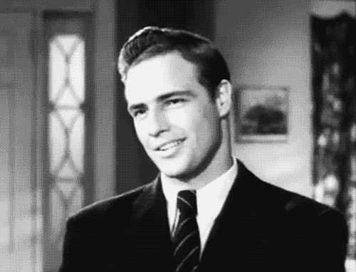 Man in Suit Smiling at Camera in Black and White