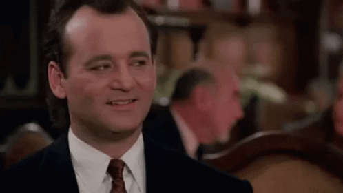 Man in Suit Smiling at Table