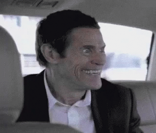 Man In Suit Smiling In Back Seat Of Car GIF