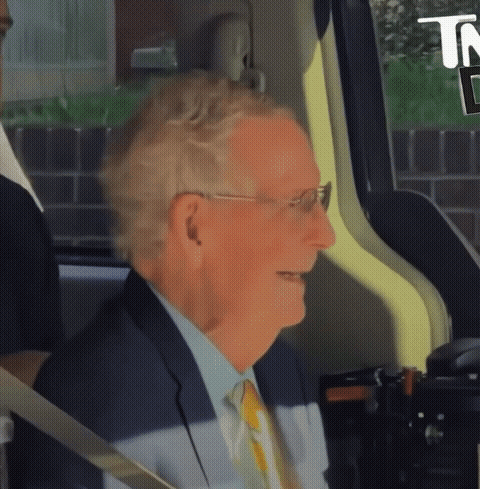 Man in Suit Smiling in Back Seat of Car