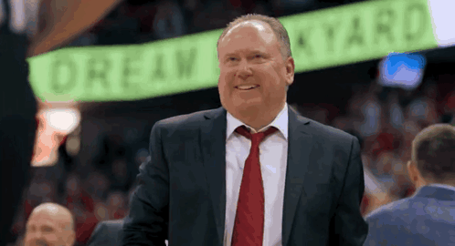 Man in Suit Smiling in Front of Drew Star Sign