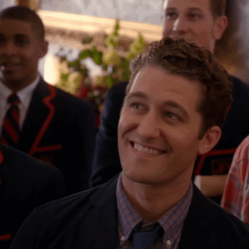 Man in Suit Smiling in Front of Group