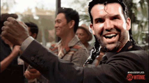 Man In Suit Smiling In Front Of Showtime Sign GIF