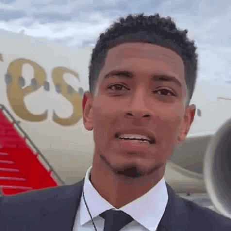 Man in Suit Smiling Next to Plane Saying ESS