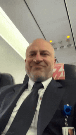 Man in Suit Smiling on Airplane