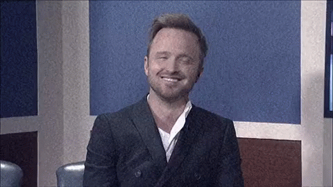 Man in Suit Smiling Sitting in Room