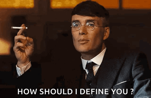 Man In Suit Smoking Cigarette Asking How To Define You GIF